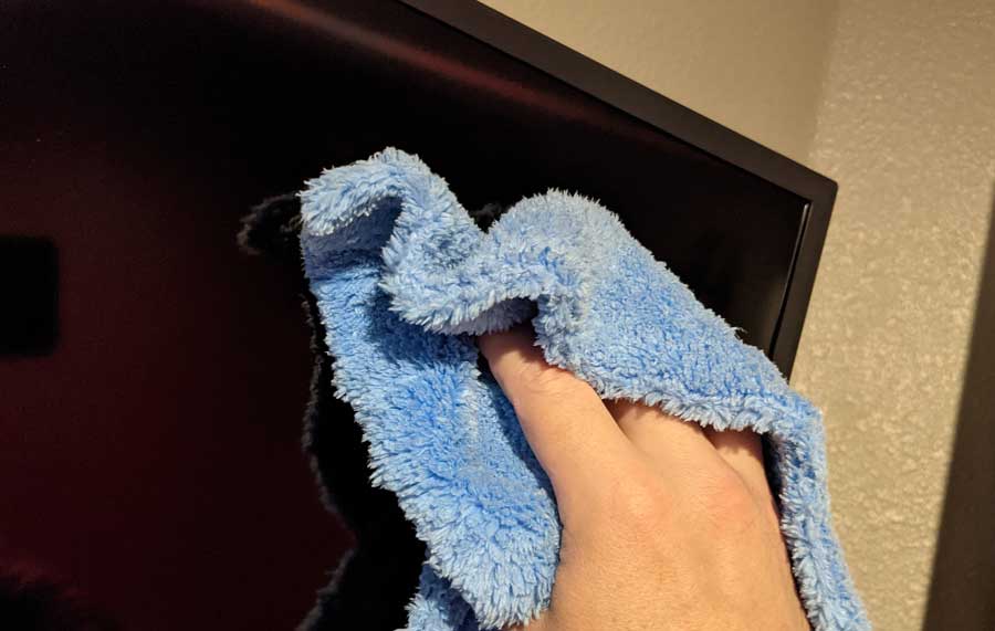 Cleaning smart TV screen with microfiber cloth